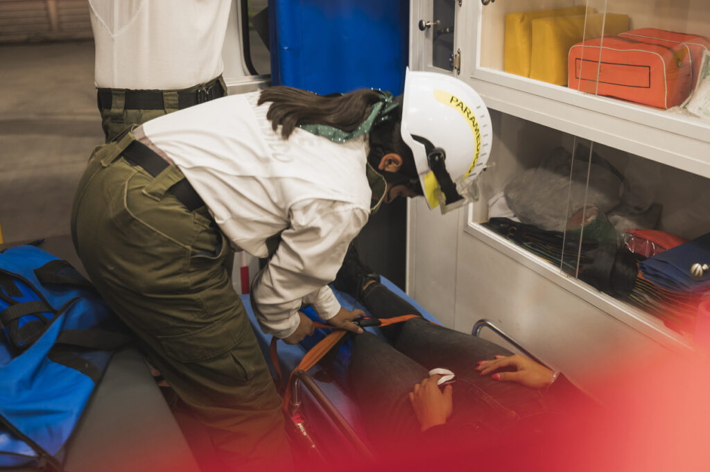 female paramedic providing first aid to a truck accident injured victims